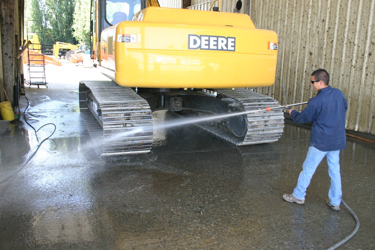 Man washing industrial equipment