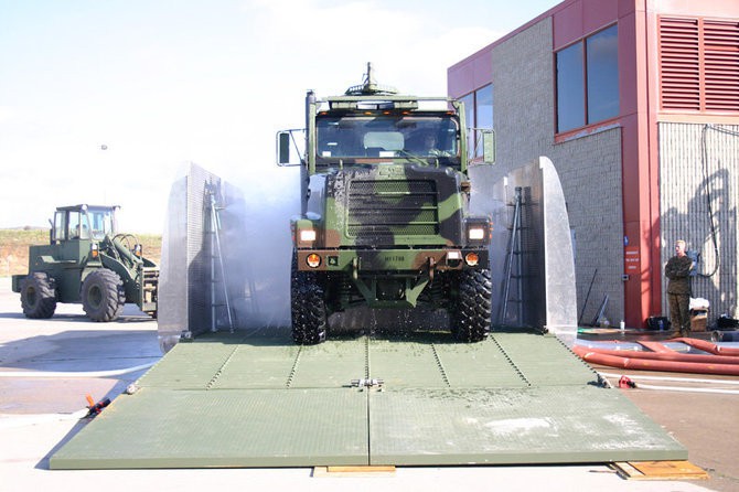 Military vehicle in fleet wash tunnel